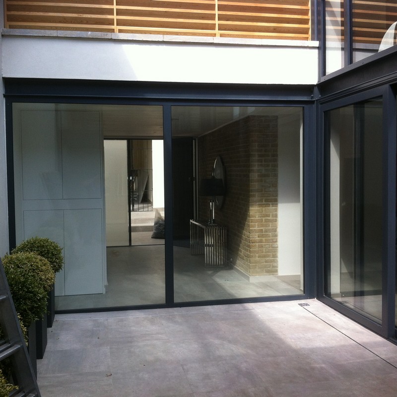 Floor-to-ceiling sliding doors opening to courtyard in New Malden